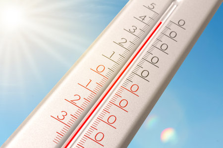 Extremely high temperature on thermometer against blue sky on sunny day. Summer weatherの写真素材