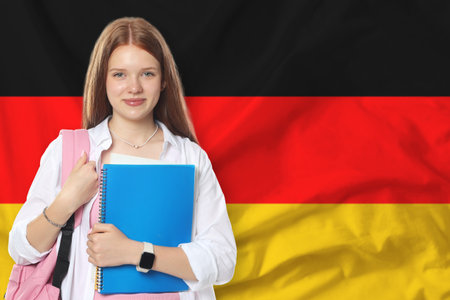Student with notebooks and backpack against flag of Germany. Language schoolの写真素材