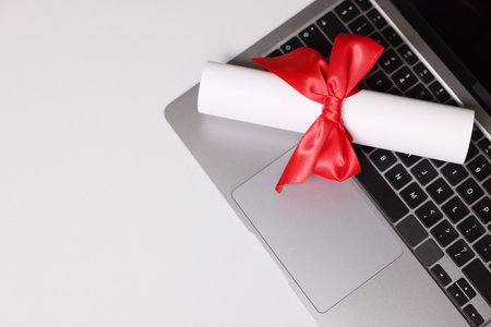 Diploma and laptop on light table, top view. Space for textの写真素材