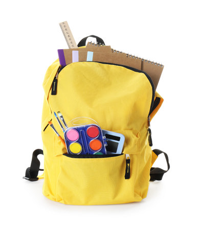Yellow backpack with different stationery isolated on white
