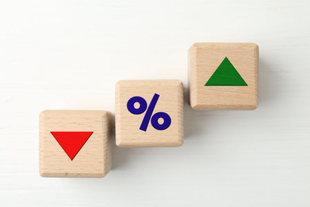Wooden cubes with percent sign, up and down arrows on white background, top viewの写真素材
