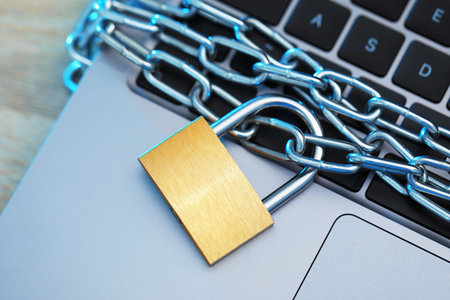 Cyber safety. Metal padlock with chain and laptop on table, top view