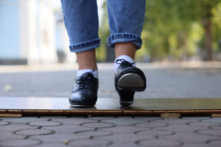 Teenage girl in tap shoes dancing outdoors, closeupの写真素材