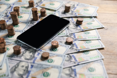 Smartphone and money on wooden table, closeupの写真素材