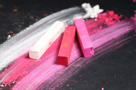 Colorful chalk pastels on black background, closeup