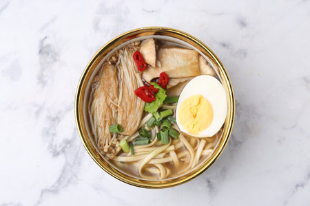 Tasty ramen with enoki and king oyster (eryngii) mushrooms on white marble table, top viewの写真素材
