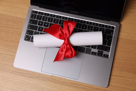 Diploma and laptop on wooden table, top viewの写真素材
