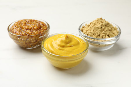 Different types of mustard on white marble table, closeupの写真素材