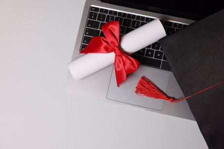 Diploma and laptop on light table, top viewの写真素材