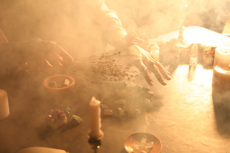 Woman doing ritual with healing stones at dark table, closeupの写真素材