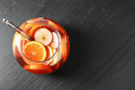 Fruity punch on black table, top view with space for text. Refreshing drink