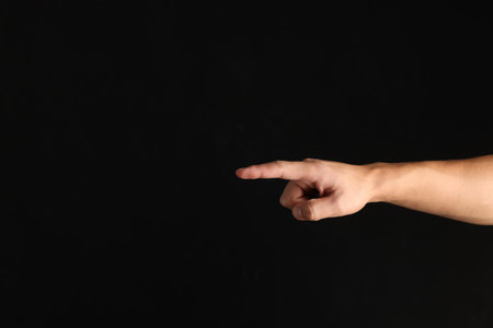 Man touching something on black background, closeup. Space for textの写真素材