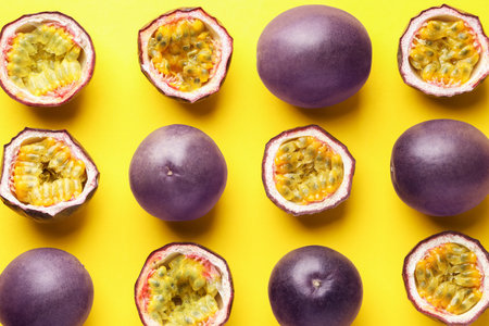 Fresh passion fruits on yellow background, flat layの写真素材
