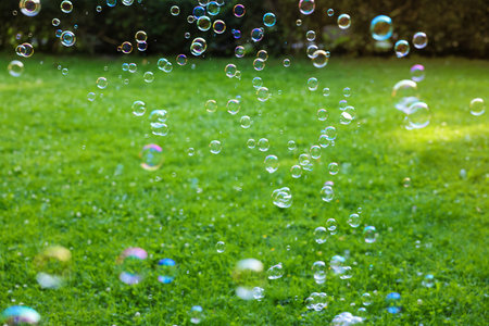 Beautiful transparent soap bubbles floating in park