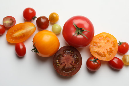 Different ripe tomatoes on white table, flat layの写真素材