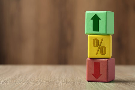 Cubes with percent sign, up and down arrows on wooden table. Space for text