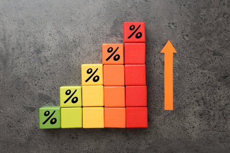 Colorful cubes with percent signs and arrow on gray textured table, top view