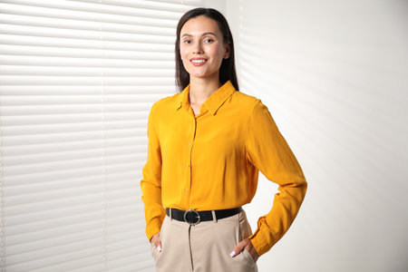 Beautiful young woman near white wall indoorsの写真素材