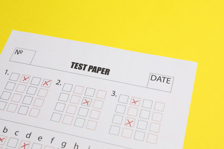 Answer sheet on yellow background, closeup. Student passing examの写真素材