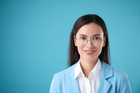 Portrait of confident businesswoman on light blue background. Space for textの写真素材