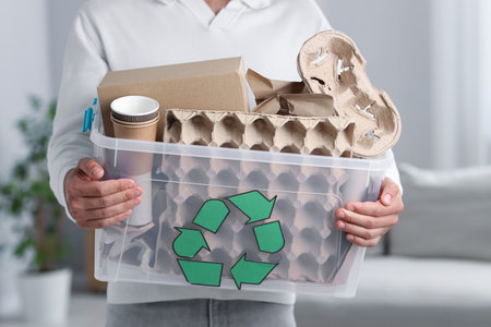 Recycling. Man holding plastic box with different waste paper indoors, closeupの写真素材