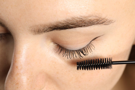 Woman applying mascara onto her eyelashes, closeupの写真素材