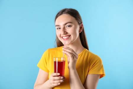 Woman with refreshing drink and straw on light blue backgroundの写真素材