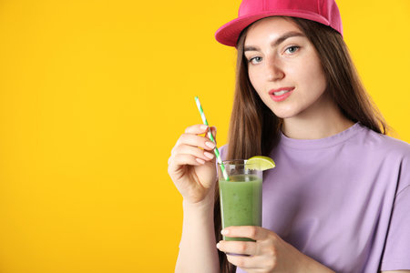 Woman with refreshing drink and straw on orange background, space for textの写真素材