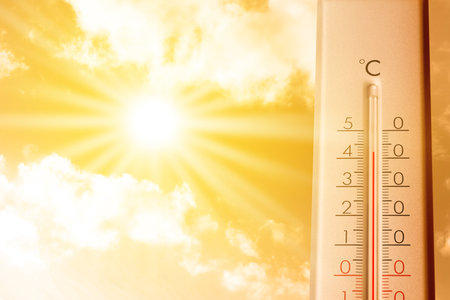 High temperature on thermometer against orange sky on sunny day. Hot summer weatherの写真素材