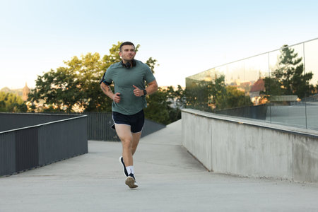 Athletic young man in sportswear running outdoors