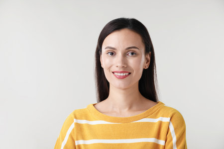 Portrait of beautiful woman on light backgroundの写真素材