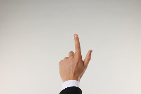 Man touching something on light grey background, closeupの写真素材