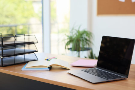 Home workspace. Modern laptop and stationery on wooden desk indoors