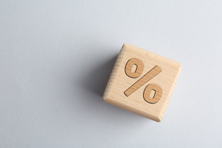 Wooden cube with percent sign on light gray background, top view. Space for textの写真素材