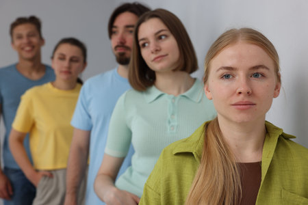 Group of people waiting in queue indoors, selective focus