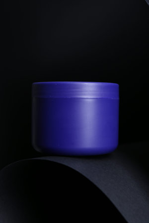 Jar of hair care product on black background