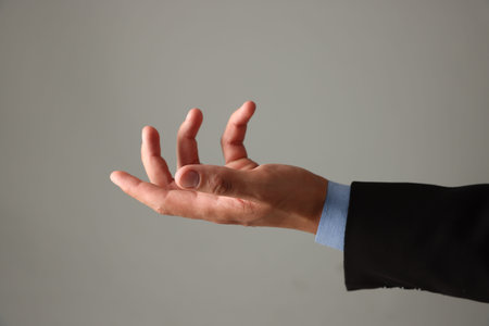 Man holding something on gray background, closeup