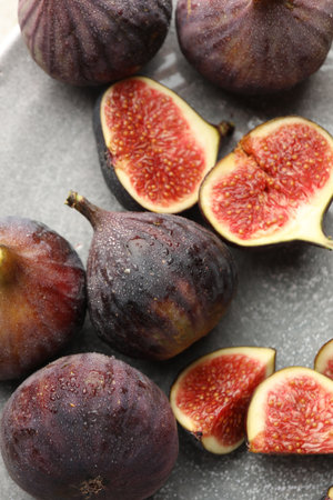Whole and cut figs on gray table, flat lay