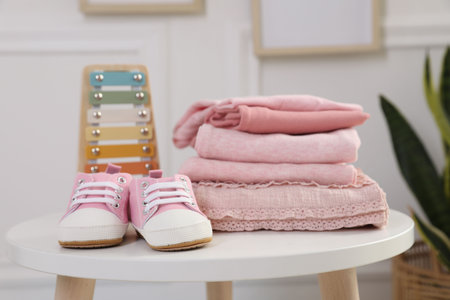 Stack of clean baby clothes and accessories on white table indoors, closeupの写真素材