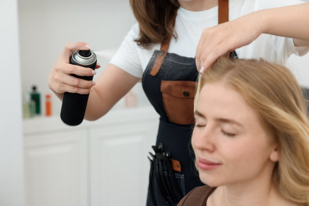 Professional hairstylist working with client in salon, closeupの写真素材