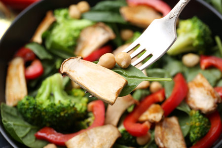 Eating tasty salad with eryngium mushrooms on blurred background, closeup