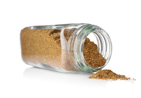 Ground caraway (Persian cumin) in glass jar isolated on white. Aromatic spice