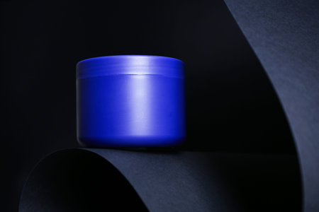 Jar of hair care cosmetic product on black background
