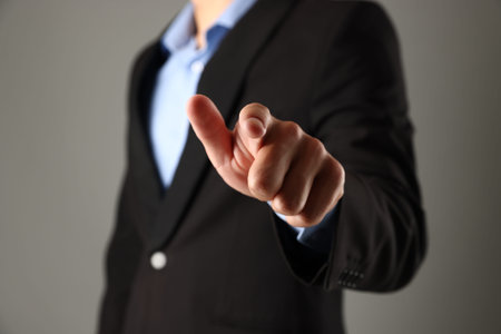 Man touching something on gray background, closeup