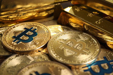 Bitcoins and gold bars on wooden table, closeup