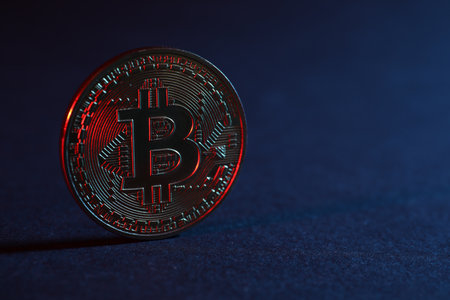 Bitcoin on blue background in red light, closeup with space for textのeditorial素材
