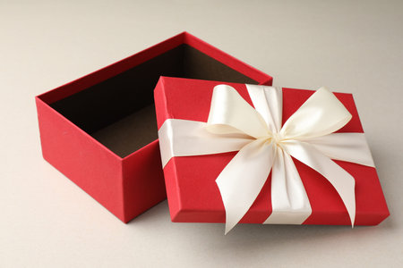 Open gift box with beautiful lid on light gray background
