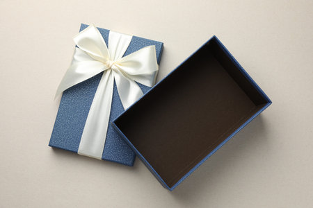 Open gift box with beautiful lid on light gray background, top view