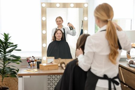 Professional hairstylist working with client in salonの写真素材