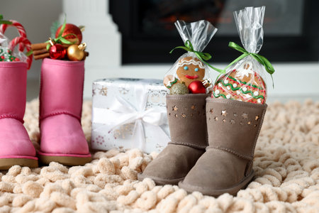 Saint Nicholas day tradition. Boots with sweets, festive decor and gift box on floor indoors